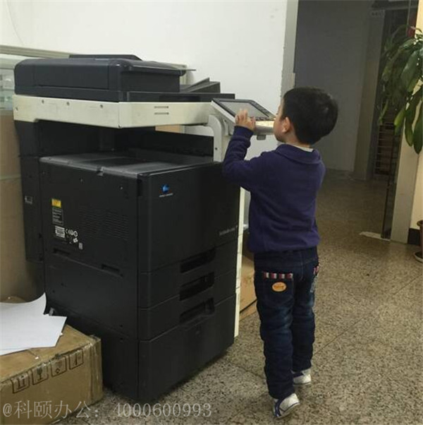 我們家小小帥掂著小腳在操作著柯尼卡美能達復印機的樣子-科頤辦公